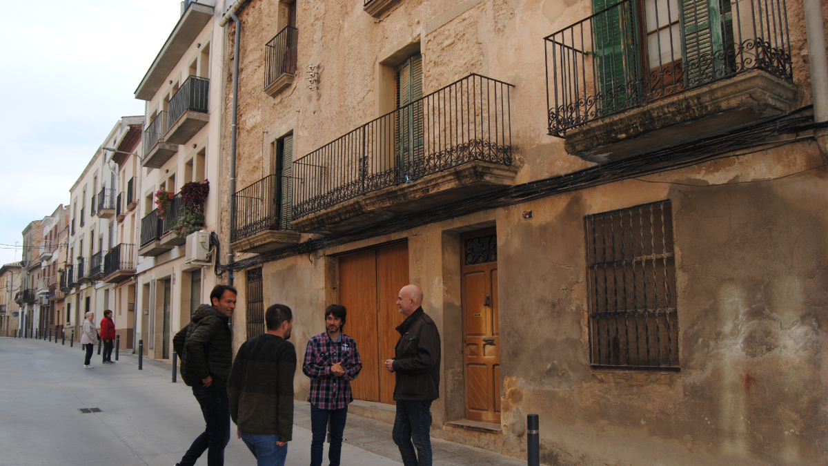 Palau y el alcalde de El Palau, Francesc Balcells, primero y segundo por la derecha, ante una casa vacía. - E. FARNELL