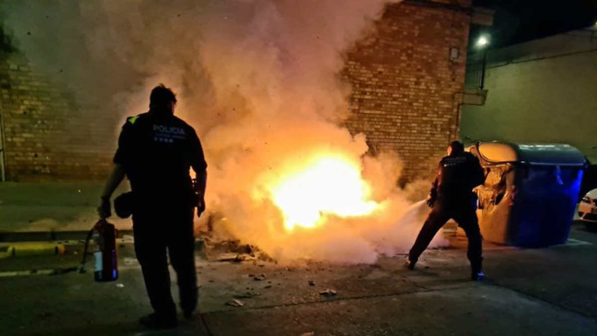 Agents de la Guàrdia Urbana actuant en l'incendi de contenidors al carrer Riu Cinca.
