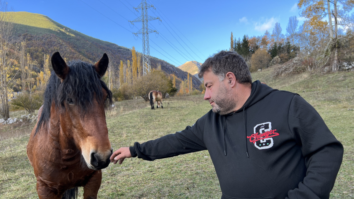 Un ganadero con un ejemplar de caballo pirenaico.