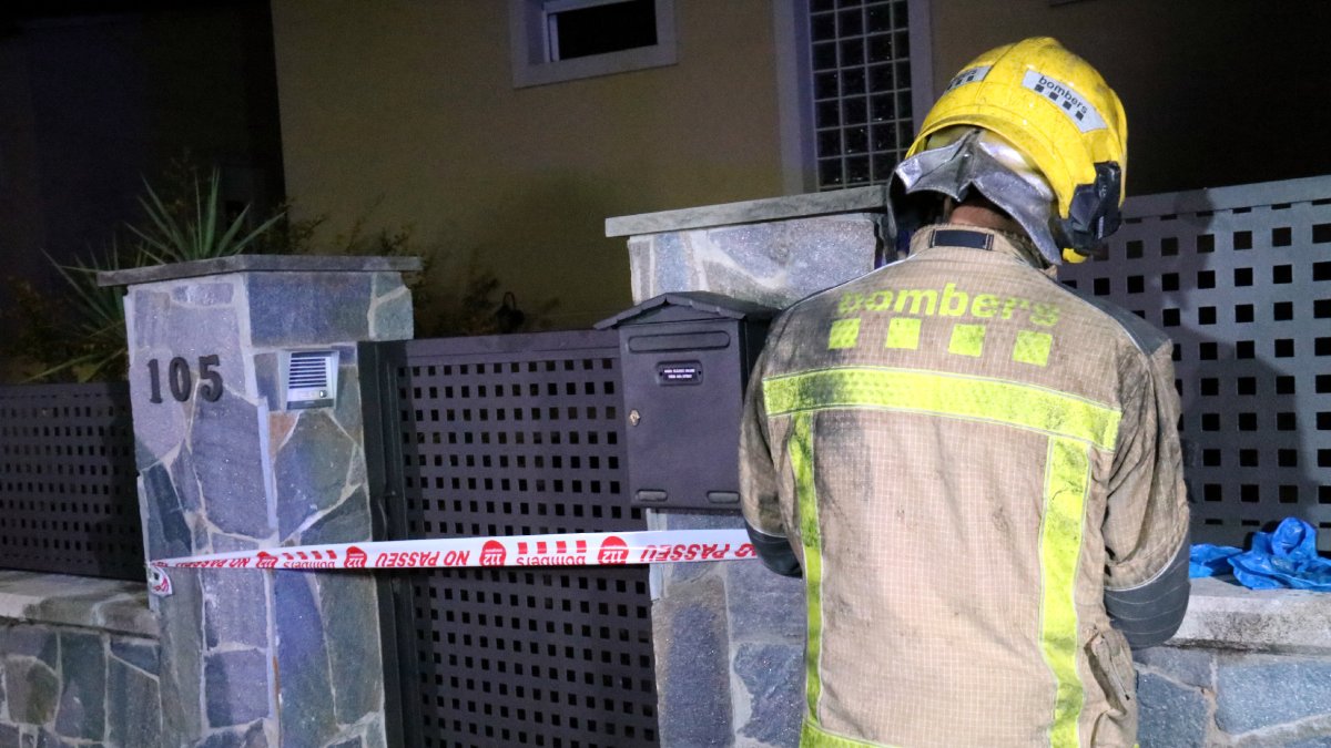 Un bomber precinta l’entrada de la casa sinistrada. - NIA ESCOLÀ/ACN