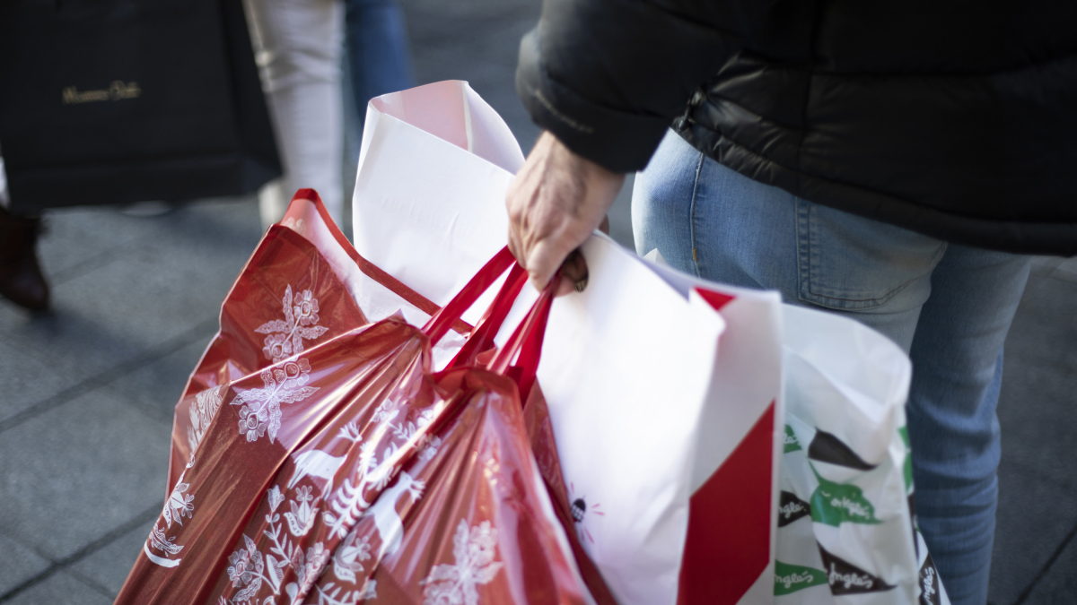 Diverses persones amb bosses de comprar en un carrer cèntric