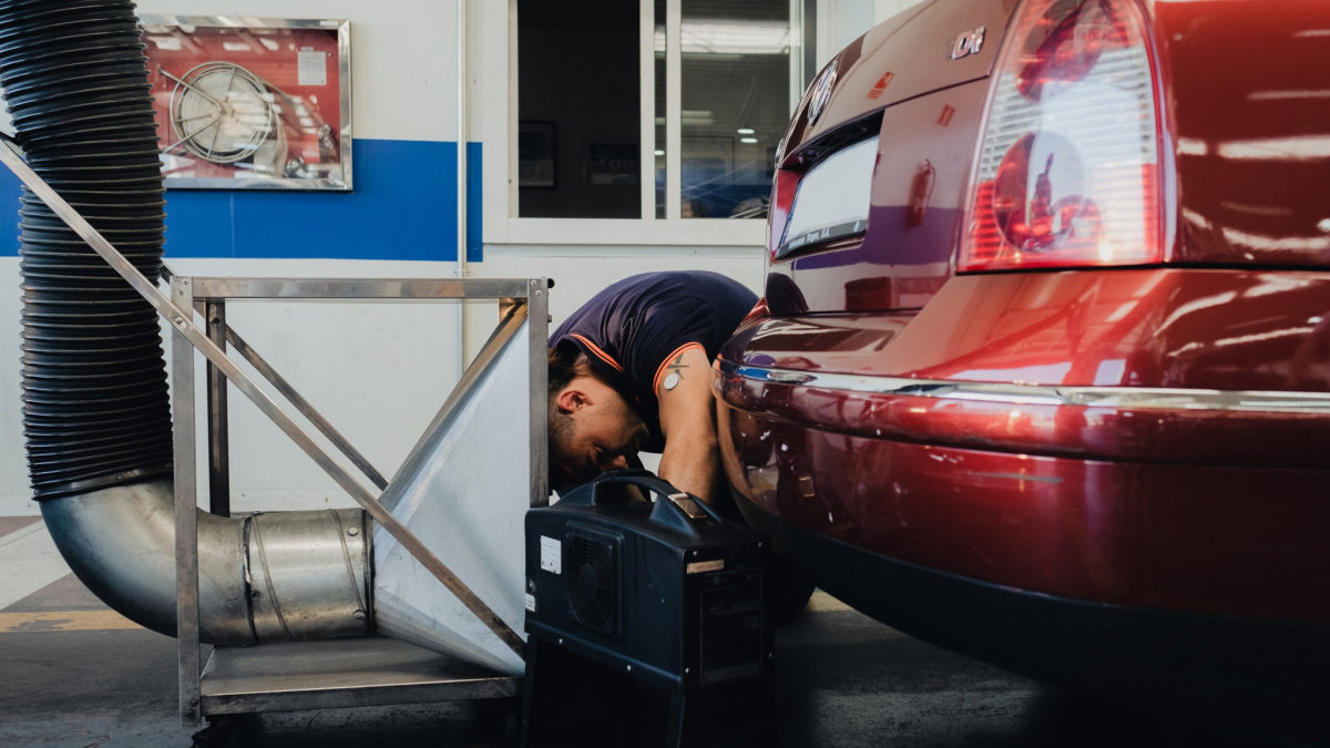 Un treballador revisant un vehicle durant la ITV.