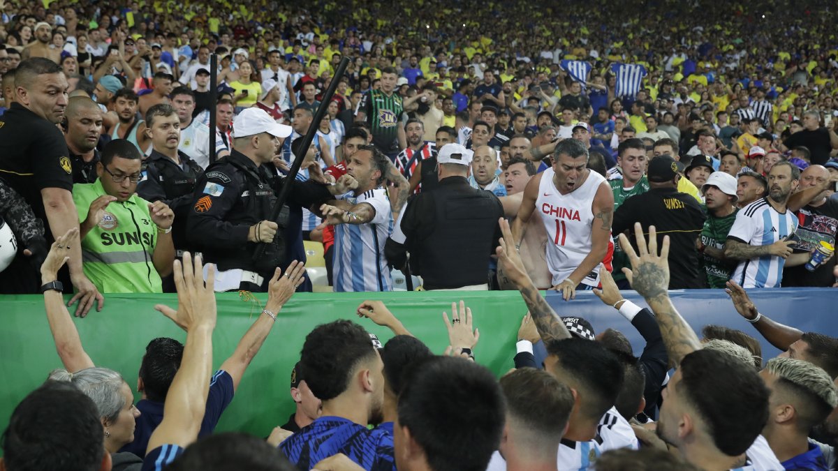 Policías brasileños con sus porras se enfrentan a hinchas argentinos. - EFE/ ANDRE COELHO