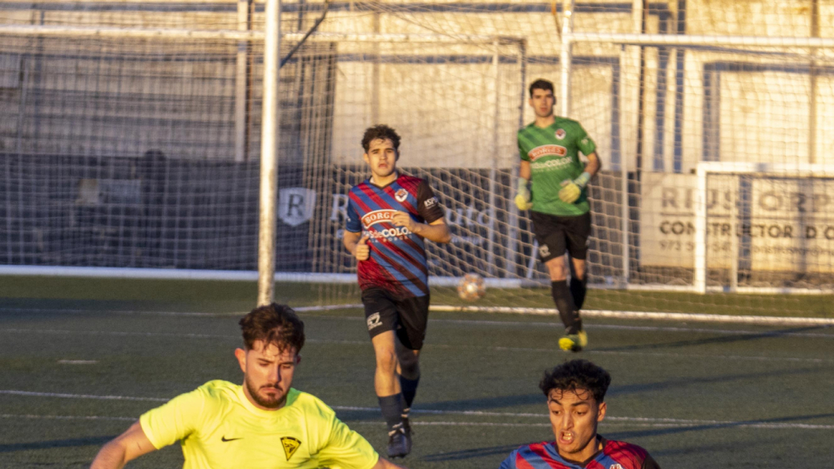 Un jugador del San Juan porta la pilota davant d’un defensa local. - XAVIER SANTESMASSES
