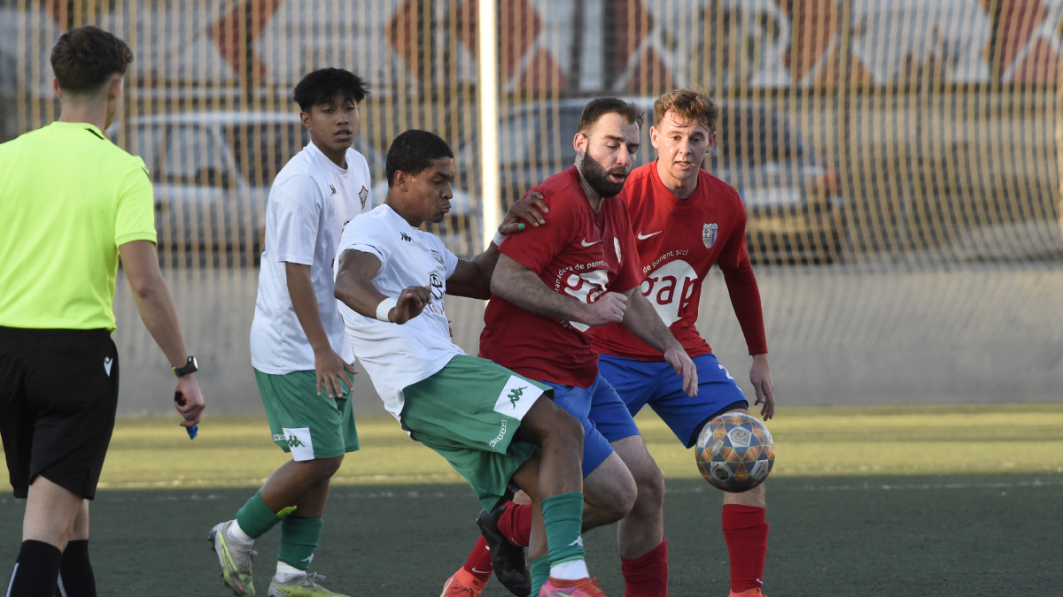 Un jugador del Balàfia intenta controlar la pilota davant la pressió de diversos rivals. - SANTI IGLESIAS