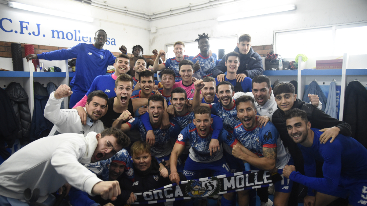 Nil Sauret, davant la pressió d’un rival de l’Escala, que va jugar el partit amb la segona equipació del Mollerrussa. - SANTI IGLESIAS