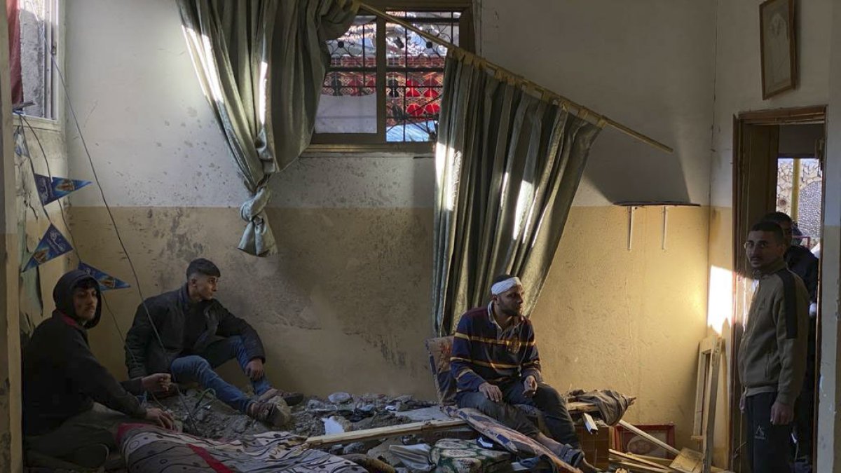 Civils palestins amuntegats entre les ruïnes d’una casa a la Franja de Gaza. - EFE/ANAS BABA