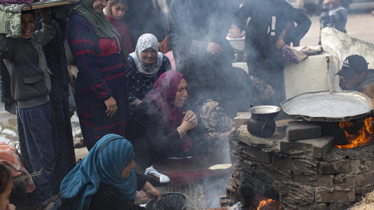 Familias palestinas desplazadas hacen pan en un horno de leña en un campo de refugiados en Rafah. - EFE/ HAITHAM IMAD
