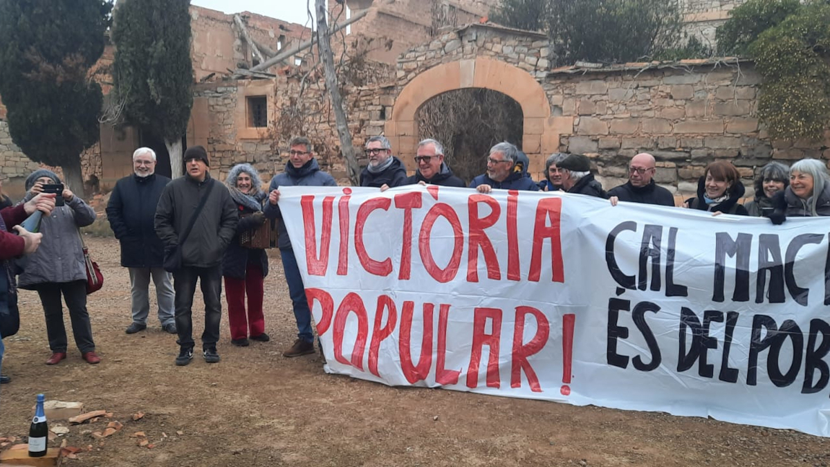 Els assistents han desplegat una pancarta per celebrar la restauració de la casa de Vallmanya.