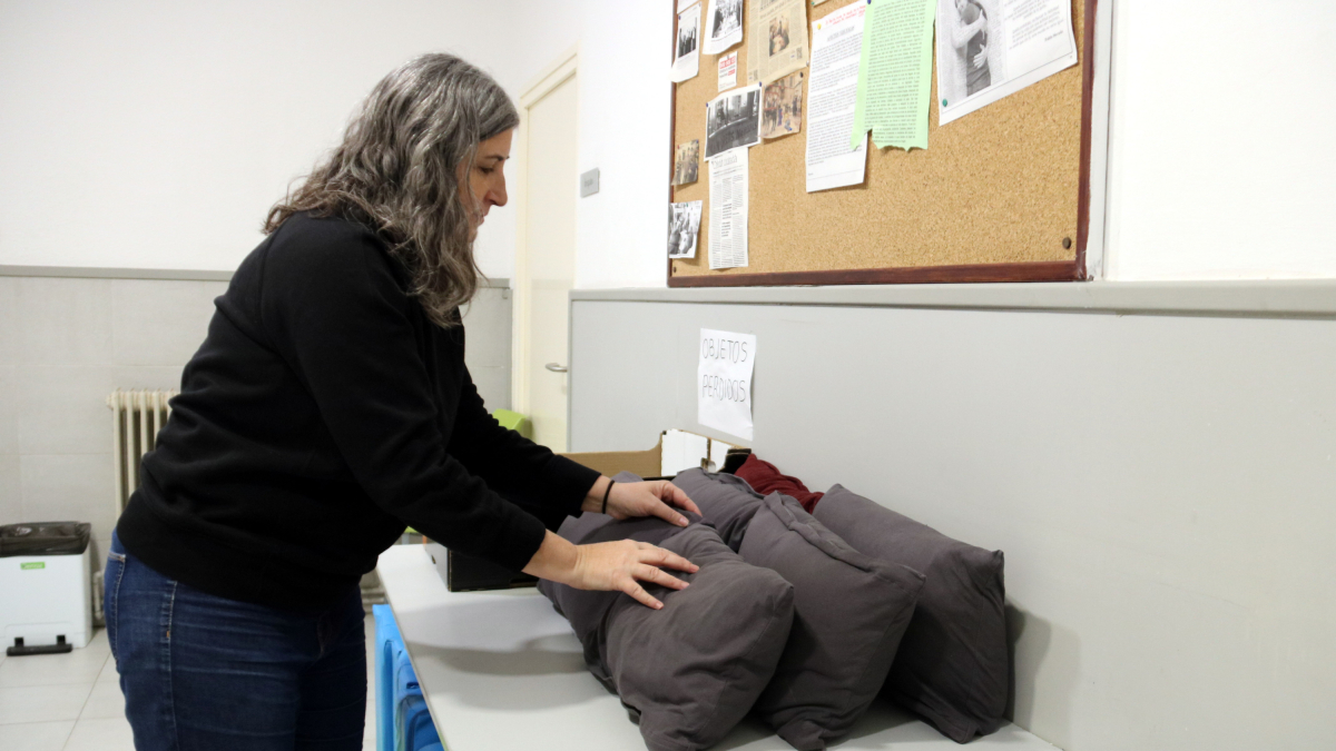 La directora de Raíces Sant Ignasi de Lleida, Rosa Majoral, ordena los cojines|almohadas que los usuarios utilizan para dormir en el Centro Abierto de la entidad