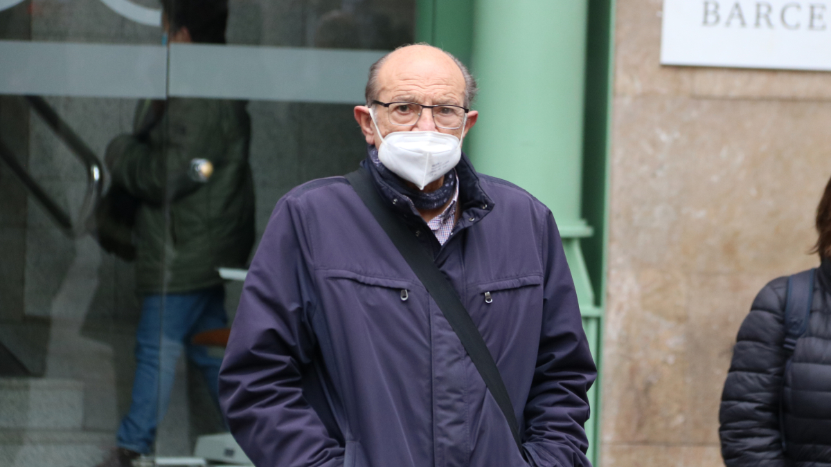 Un hombre saliendo de una clínica con la mascarilla puesta