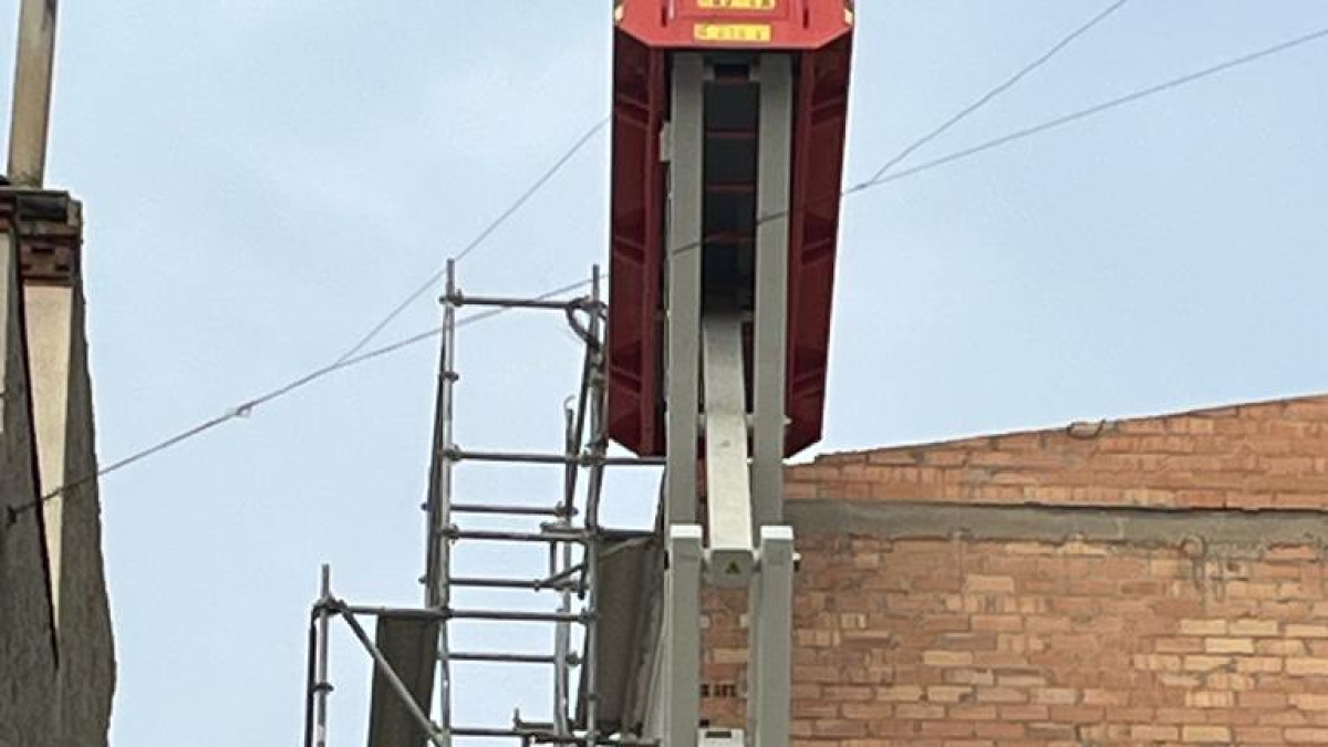 Un operari amb vestit de protecció per retirar el fibrociment de la coberta de l’Escola del Treball. A la dreta, part de la uralita que hi havia. Ara ja no en queda. - ESCOLA DEL TREBALL