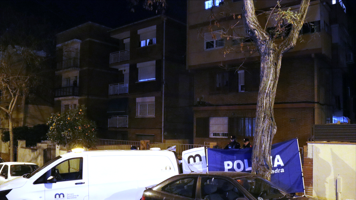 Una furgoneta funerària al davant de l’edifici del passeig Universal de Barcelona on s’han trobat els cossos d’un home i dels seus dos fills menors d’edat.