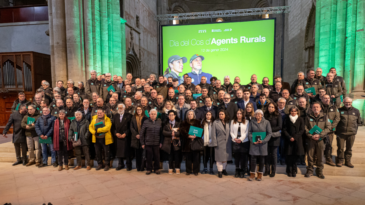 Foto grupal de autoridades, agentes y familias reconocidas en el acto del Día del cuerpo de los Agentes Rurales, ayer en Lleida. - JORDI ECHEVARRIA