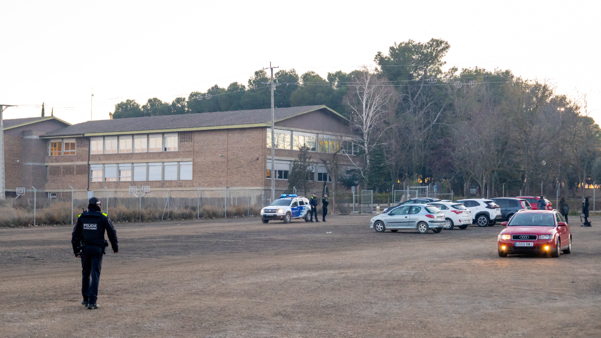 Agents de la Guàrdia Urbana vigilant ahir a la tarda el pàrquing del centre educatiu. - JORDI ECHEVARRIA