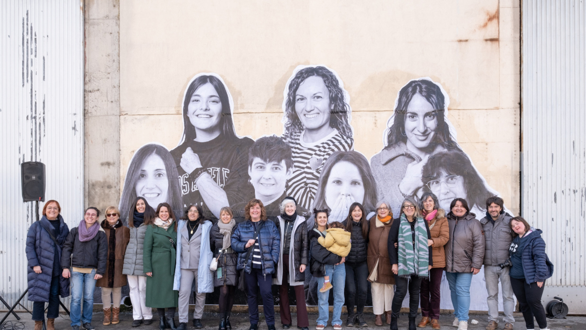 Mujeres que participan en el proyecto con el mural que las visibiliza en el Palau d'Anglesola