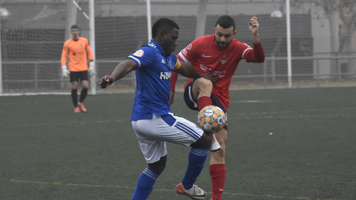 Un jugador del Lleida B lluita per la pilota davant d’un del Balaguer. - SANTI IGLESIAS