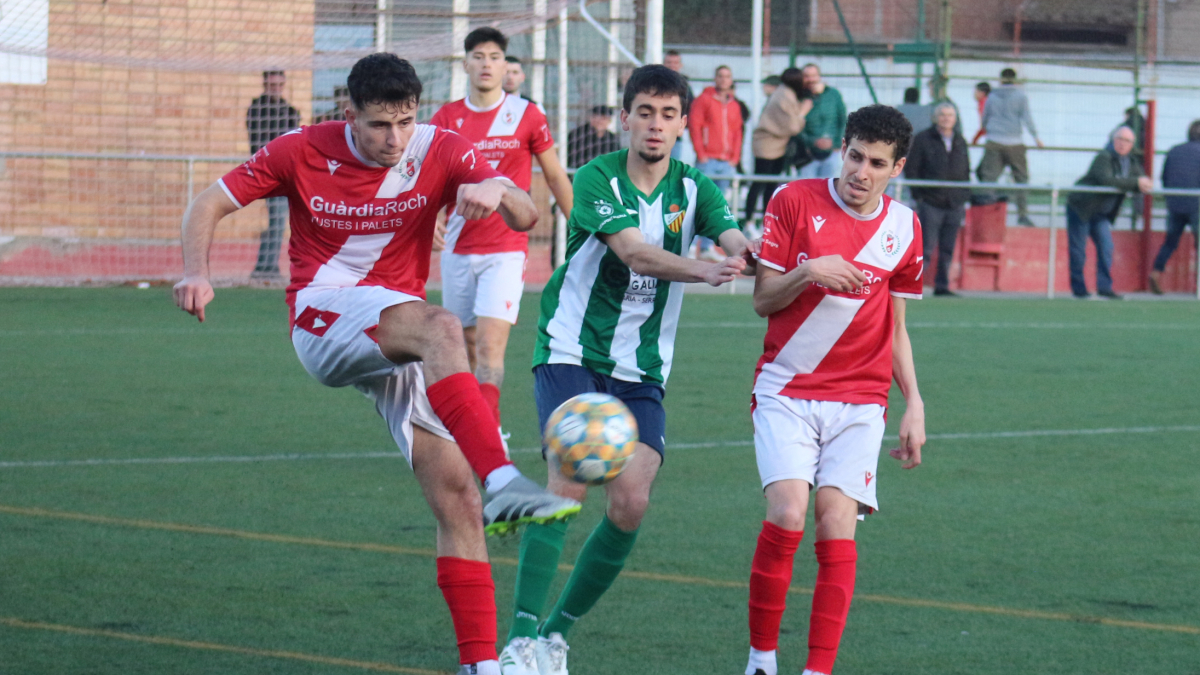 Un jugador del Artesa de Segre despeja un balón frente a la presión de un rival. - JOAN BOVÉ