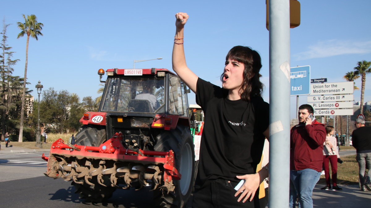 Una noia dona suport al pas dels tractors per la Zona Universitària, a l'avinguda Diagonal