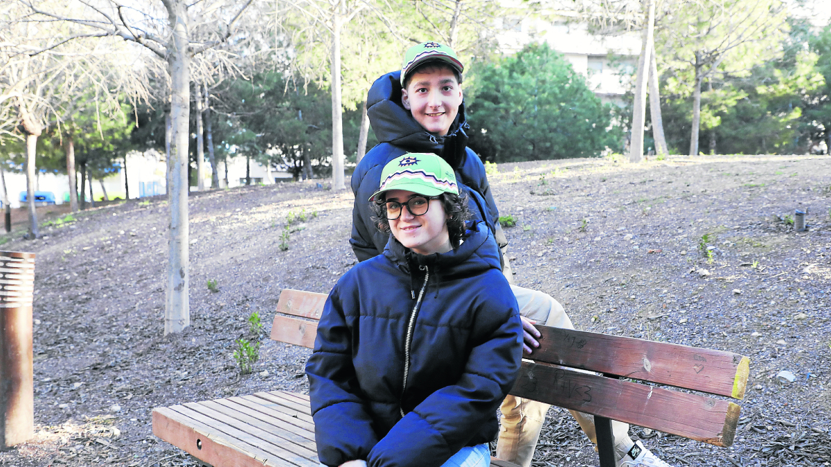 Ares Santiago, de 18 anys, i David Pujol, de 17, posen amb la gorra de la festa solidaria d'Afanoc Lleida.