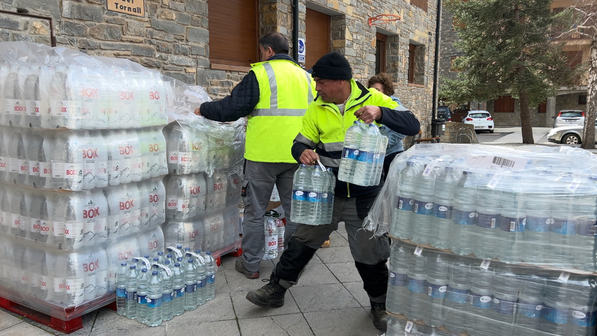 Operaris de l'ajuntament de Rialp descarregant aigua a l'ajuntament de Rialp per als veïns
