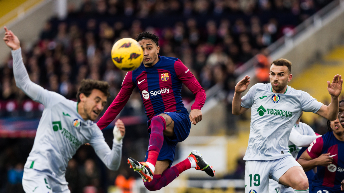 Raphinha, que va obrir el camí del triomf blaugrana, vola per intentar controlar la pilota davant de dos jugadors del Getafe. - EUROPA PRESS