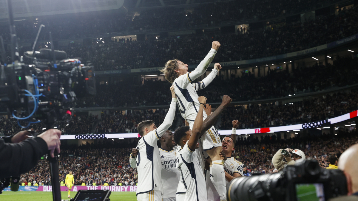 Luka Modric, acompanyat pels seus companys, celebra el gol del triomf sobre una tanca publicitària. - EFE/JAVIER LIZÓN