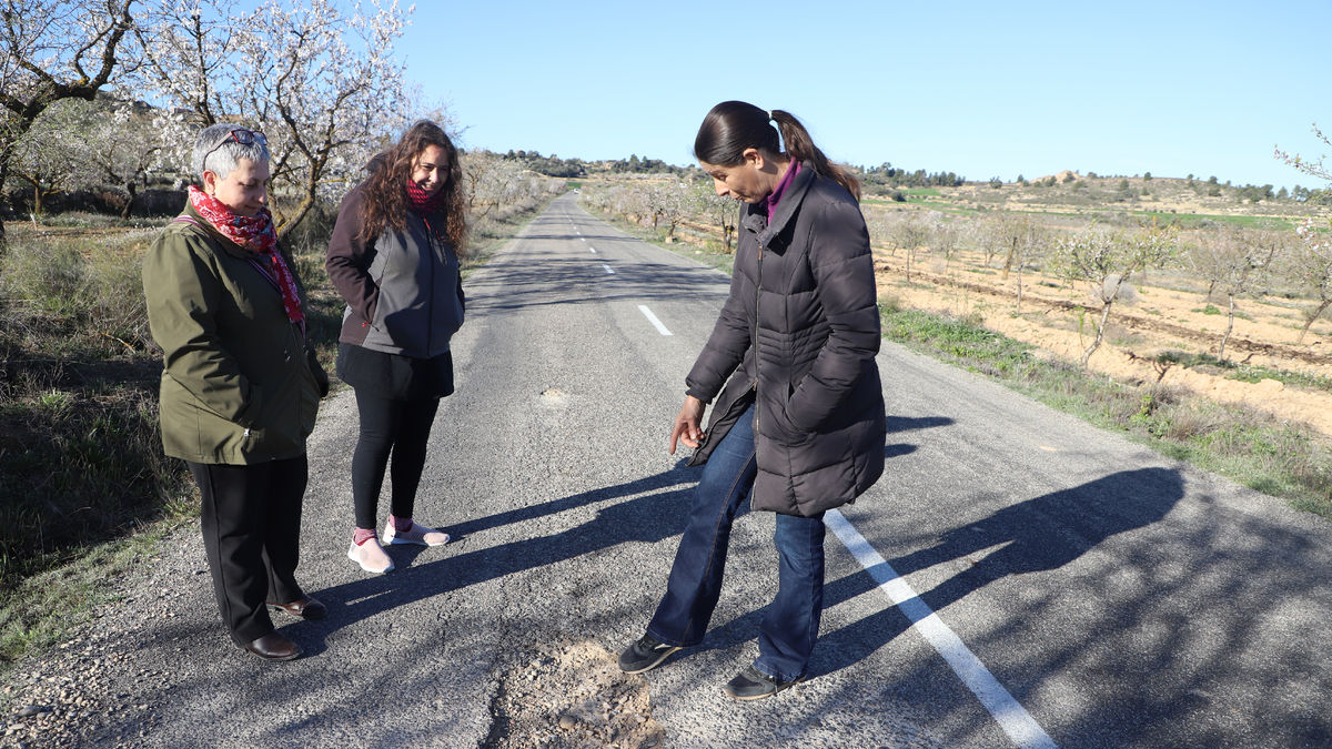 En el centro y la derecha, la alcaldesa de El Cogul y la de Granyena mostrando un socavón. - MAGDALENA ALTISENT