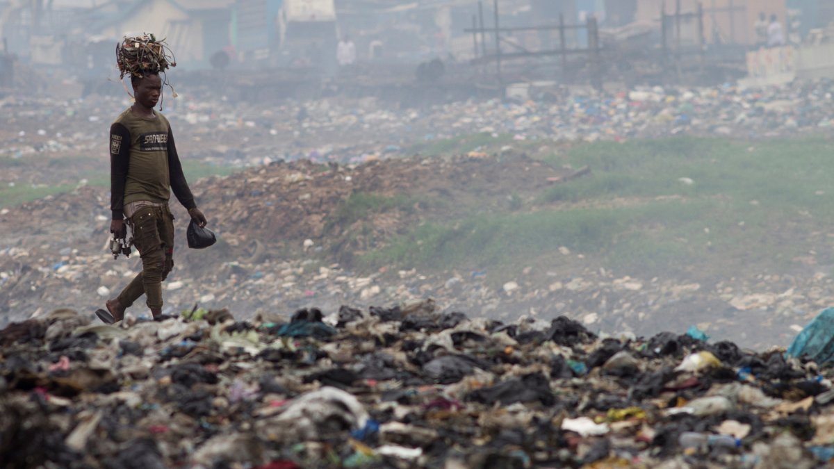 Un home transporta cables sobre el seu cap a l’abocador d’Agbogbloshie, un barri d’Accra, capital de Ghana, considerat l’abocador d’escombraries electròniques més gran del continent Africà.