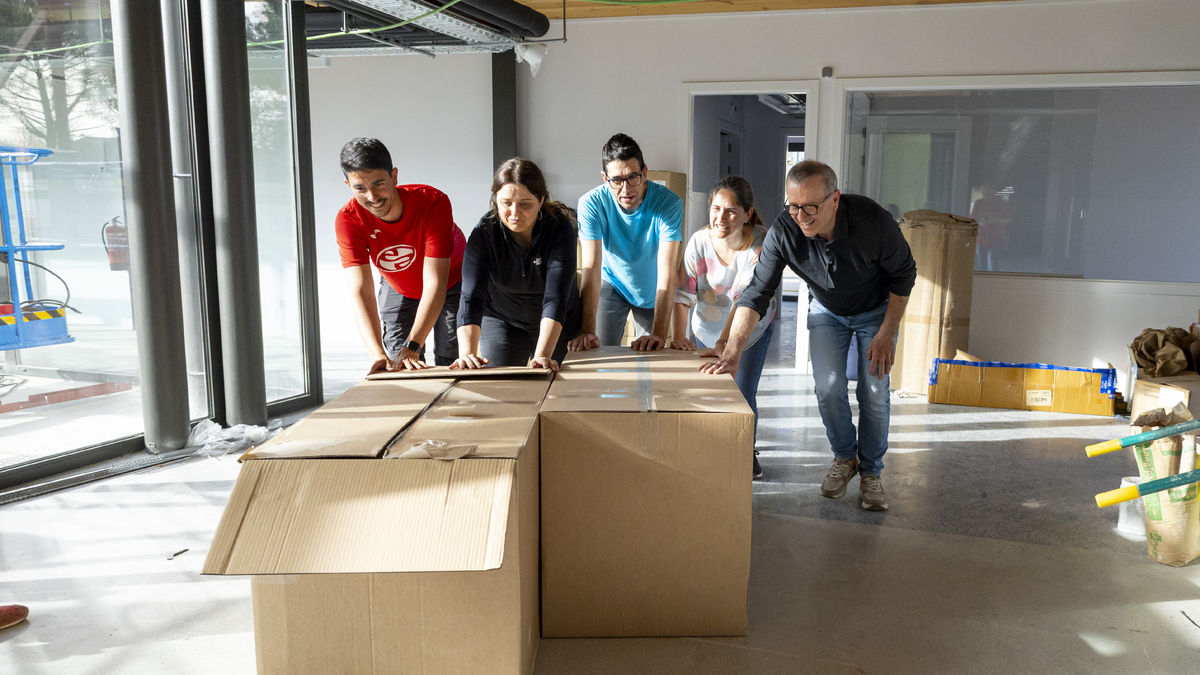 Miembros de la asociación de familias de alumnos (AFA) y concejales moviendo ayer cajas con muebles. - JORDI ECHEVARRIA