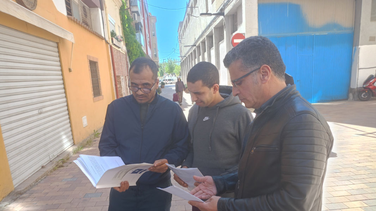 Tres de los inquilinos repasan los documentos del juzgado tras la vista oral celebrada ayer. - E.B.