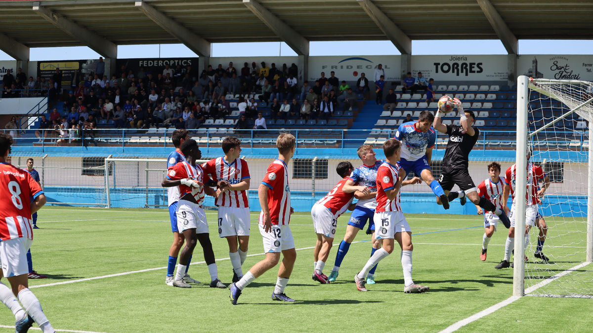 El porter del Girona B atrapa un córner, impedint la rematada a Jordi Ars.