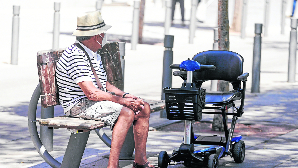 Un pensionista sentado en un banco en Madrid.