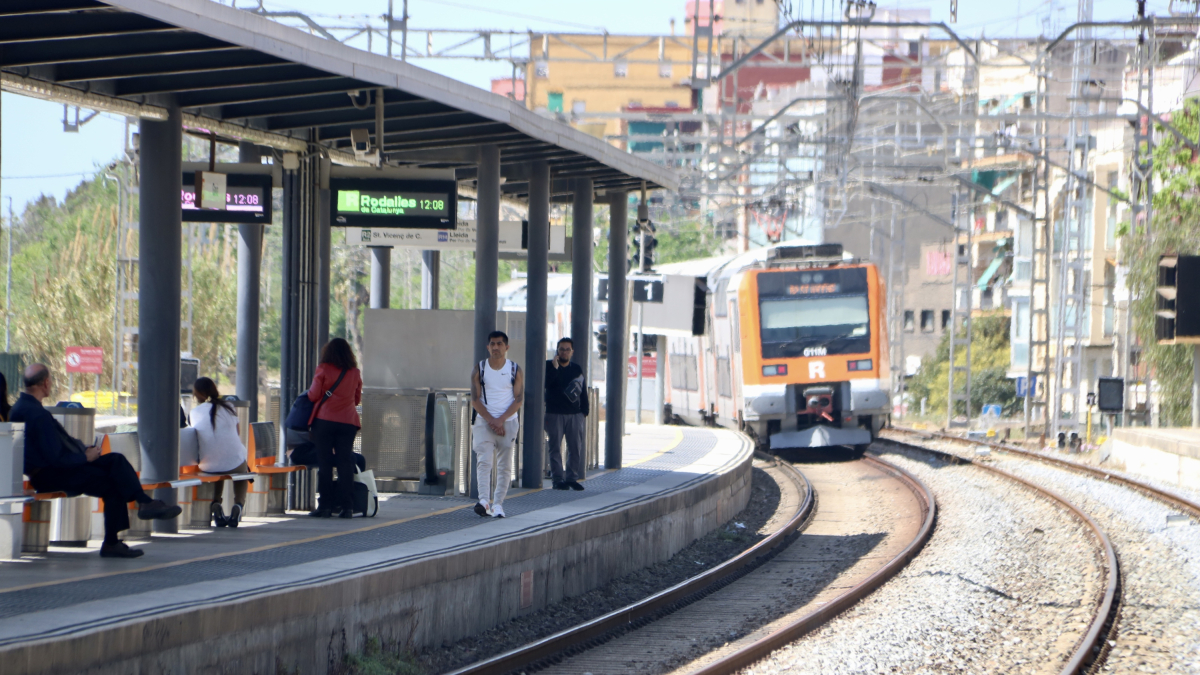 Passatgers esperant a l’andana l’arribada d’un tren a l’estació de Rodalies de Gavà.