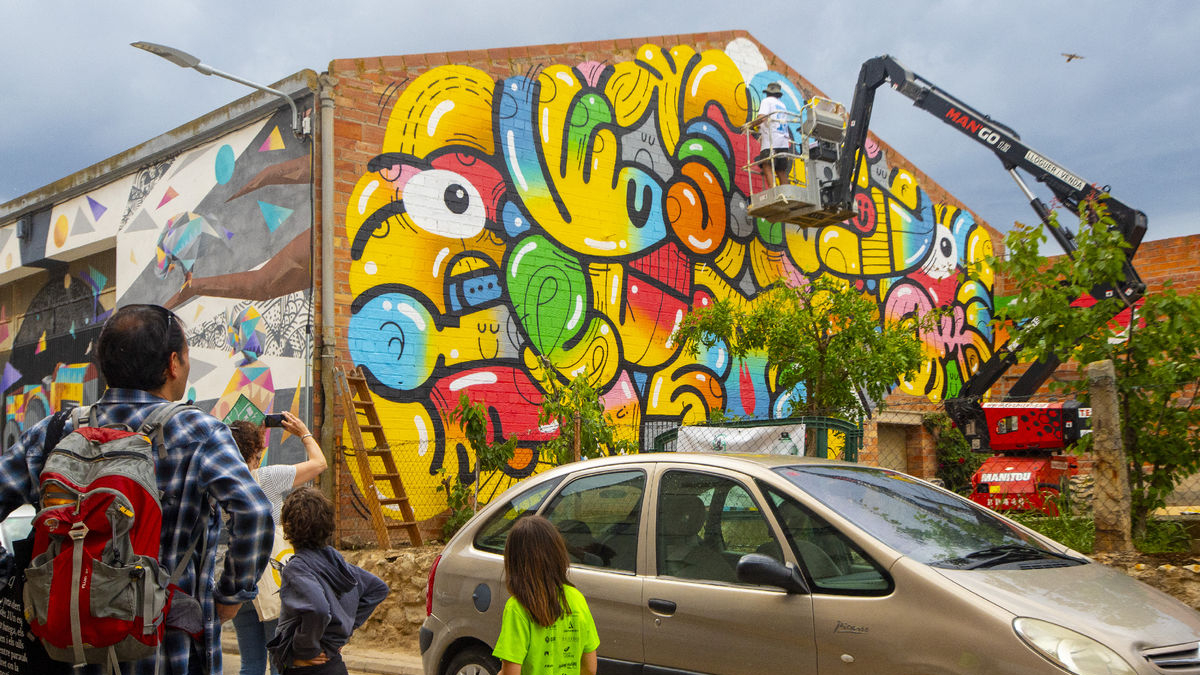 El públic va poder presenciar ahir els últims retocs als murals de Penelles. - GERARD HOYAS