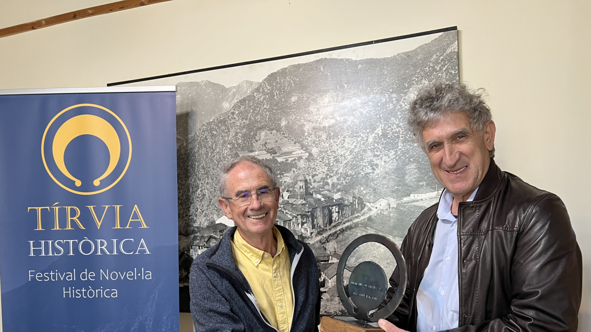 El alclade de Tírvia, Joan Farrera, entrega el galardón  al escritor Pep Coll.