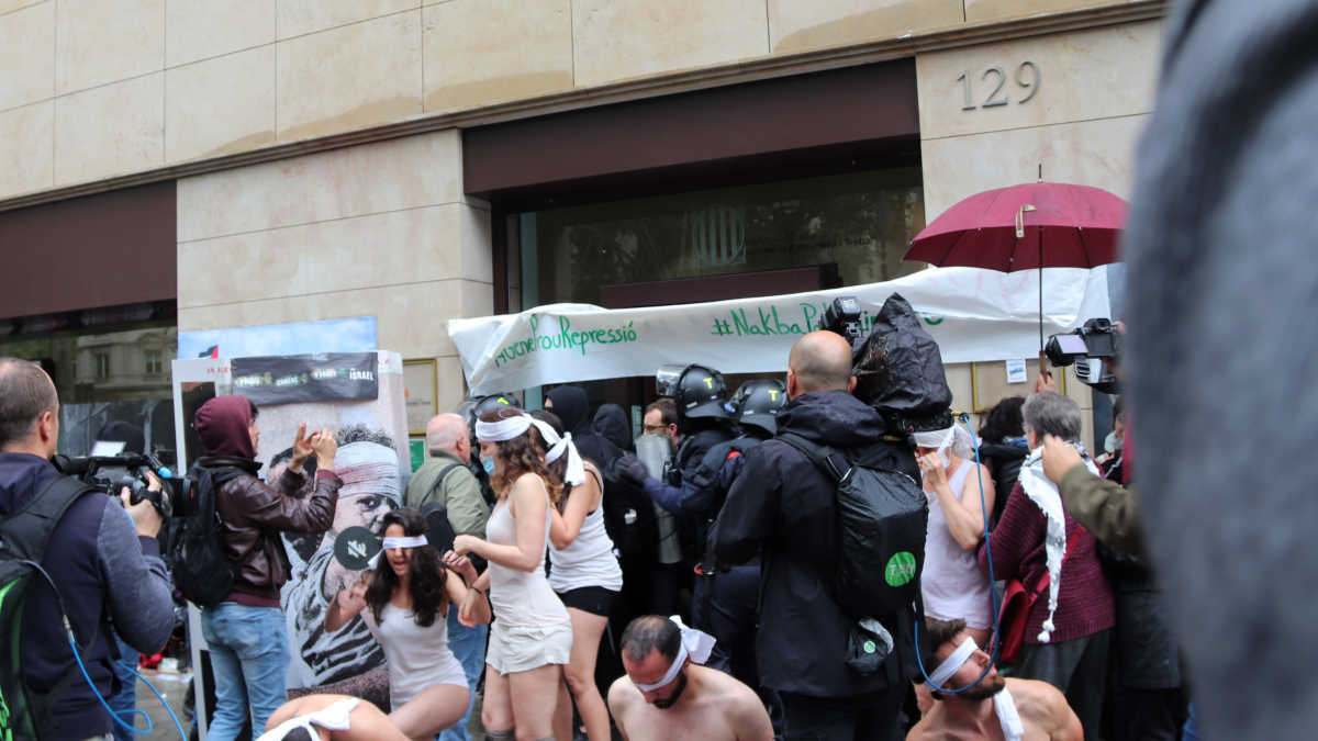 Los Mossos desalojan a los activistas pro palestina que han ocupado la sede de Acció mientras hacían una 'performance' sobre la vida en una prisión israelí