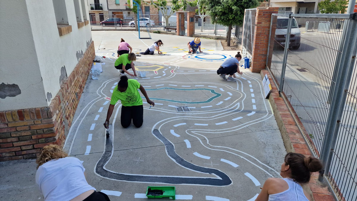 Diverses mares en plena tasca de millora del pati del col·legi. - LAIA PEDRÓS