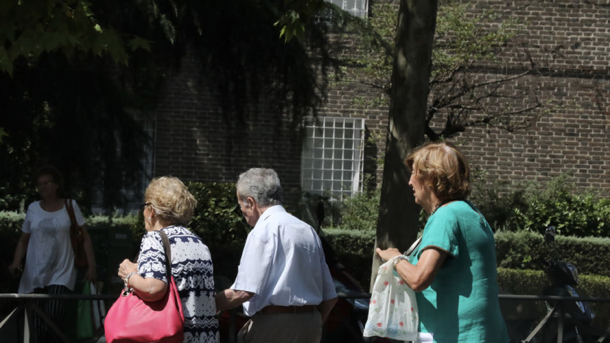 Un grup de persones grans passegen per un parc aprofitant el bon temps. - EUROPA PRESS