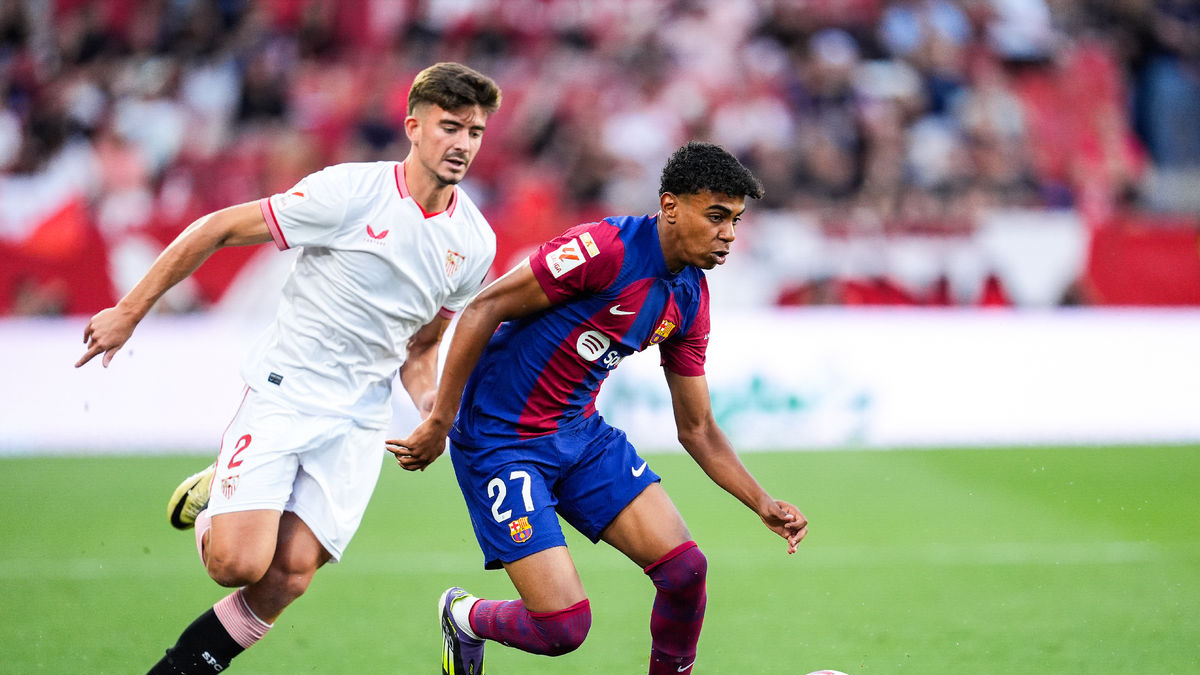 Lamine Yamal condueix la pilota perseguida pel sevillista Kike Salas. - EFE