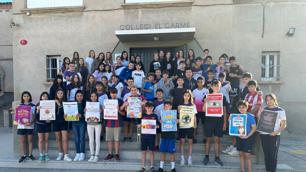 Els alumnes del col·legi El Carme, amb els cartells que han dissenyat, ahir abans de començar a penjar-los per la Bordeta. - ESCOLA EL CARME