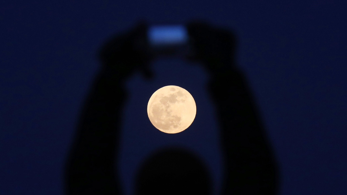 Fotografia d’arxiu d’una persona que fa una foto de la lluna a Pequín, Xina.