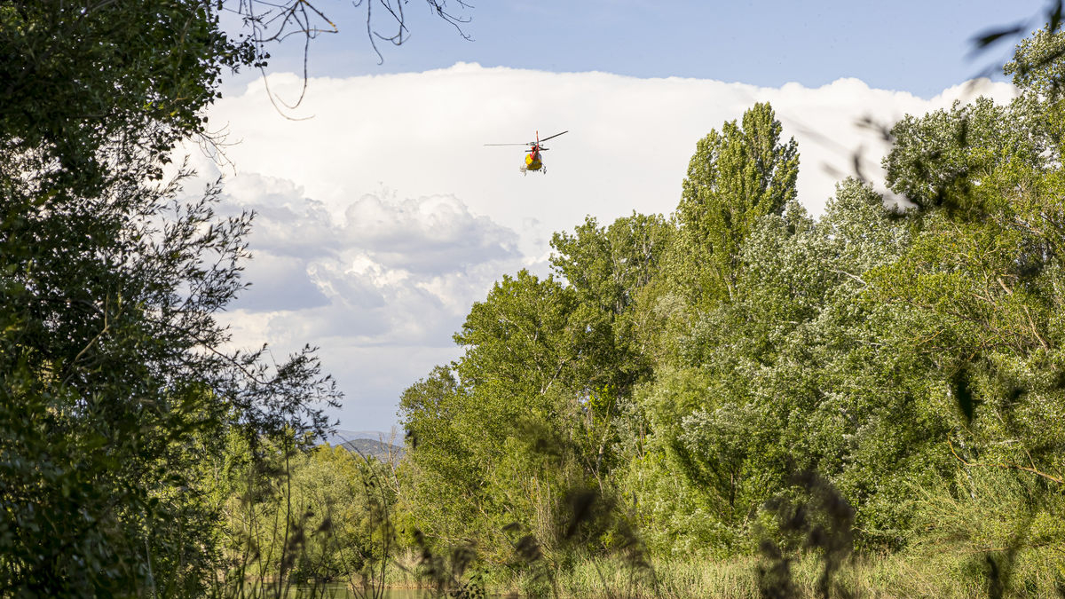 El helicóptero de los Bomberos, ayer mientras sobrevolaba el río Segre durante la búsqueda en Gerb. - JORDI ECHEVARRIA