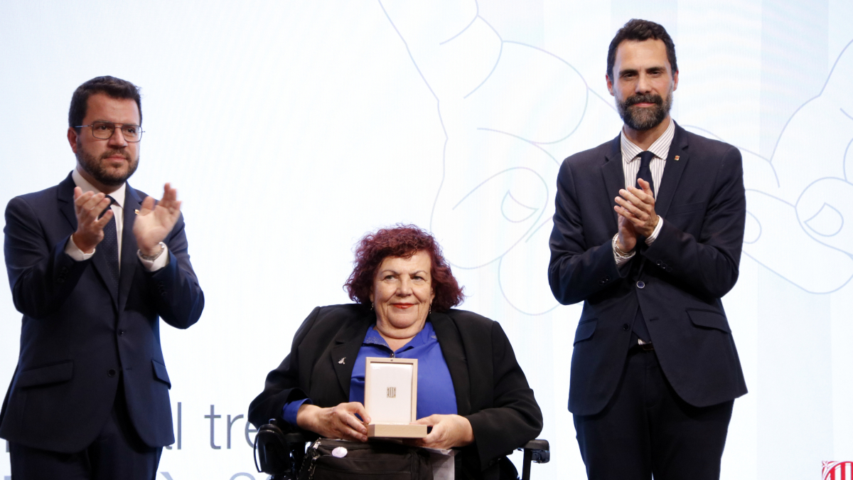 La professora i esportista paralímpica Maria Carme Riu rebent la medalla al treball president Macià.