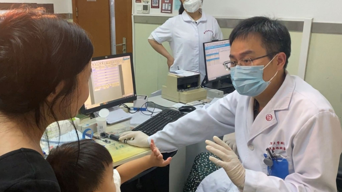 El Dr. Yilai Shu es comunica amb un jove pacient a l’Hospital Oftalmològic i Otorrinolaringològic de la Universitat de Fudan, a Xangai.