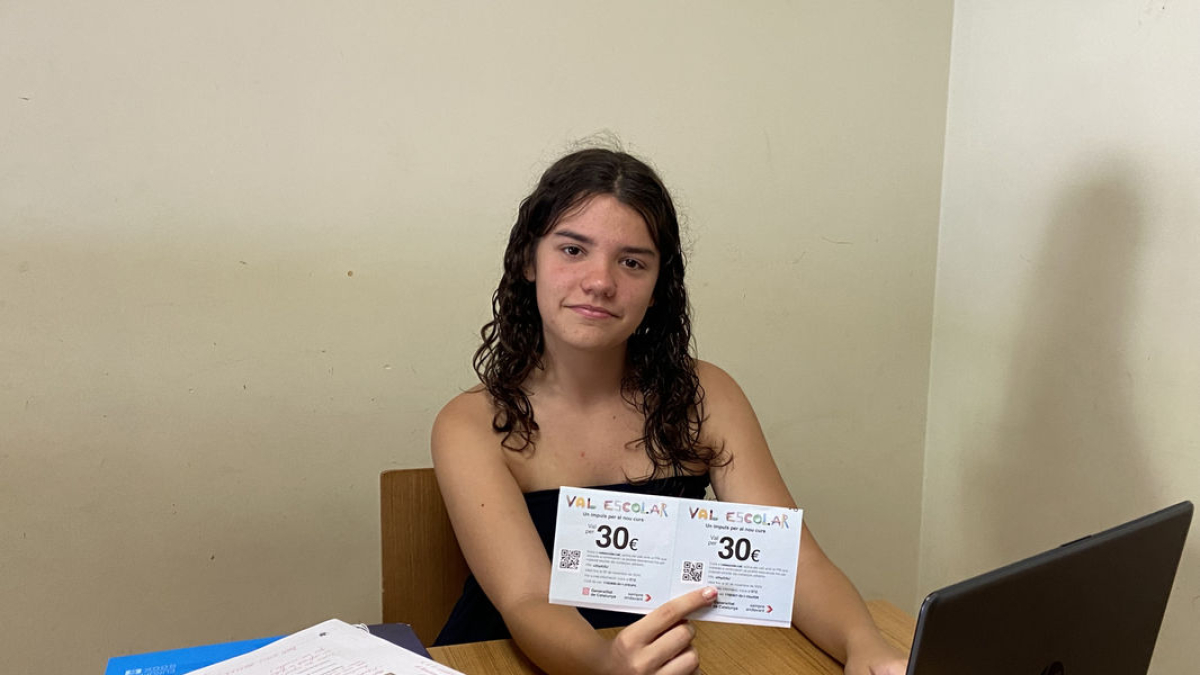 Una alumna de Secundaria de Lleida, con los vales escolares que ha recibido por correo. - AMADO FORROLA