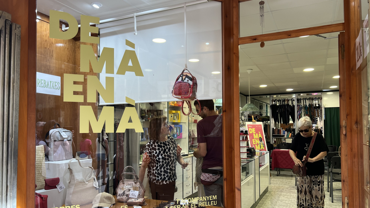 L'eslògan de la campanya 'De mà en mà' al vidre de la Perfumeria Torres de Solsona.