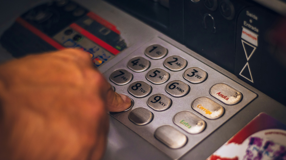 Una persona treu diners d’un caixer automàtic.