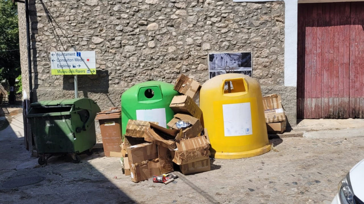 Imatge d’alguns contenidors buits mentre els residus de cartró s’acumulen al carrer. - A. COLL DE NARGÓ