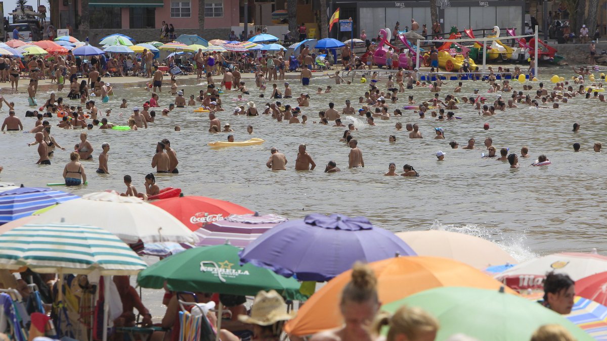 Un gran número de personas disfrutan del buen tiempo en la playa de El Cura de Torrevieja (Alicante) este martes.
